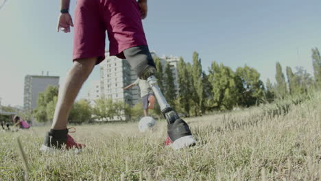 Close-up-of-mans-prosthetic-leg-kicking-ball-around